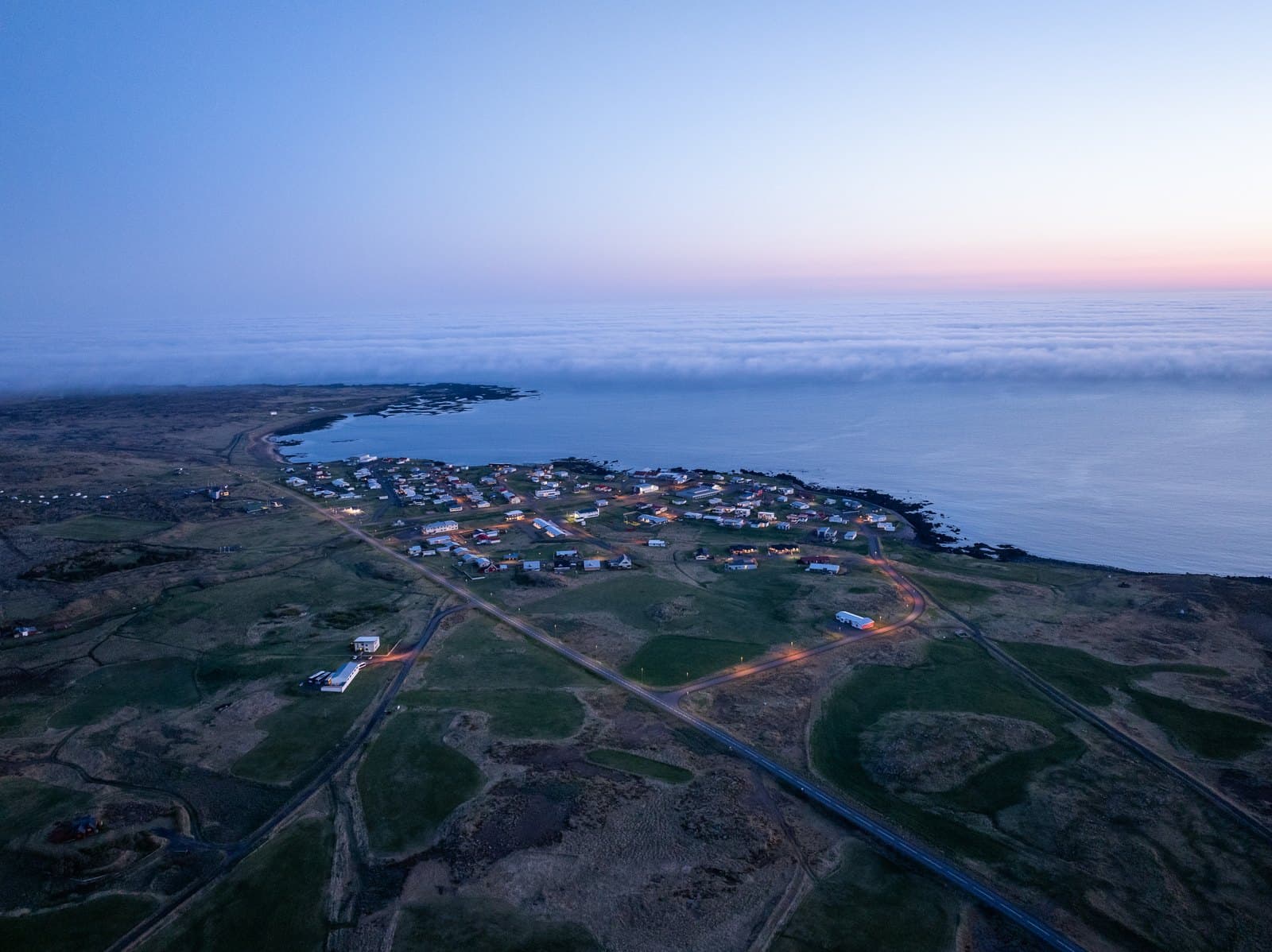 Aerial view of the Snæfellsnes coast at dusk, the road running in past the village